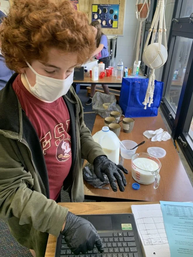 A student recording observations from a hands-on science experiment