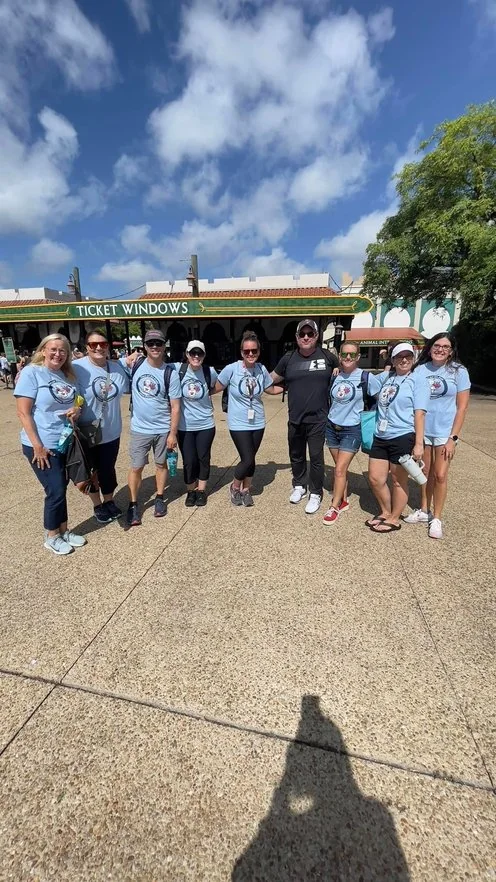 Kevin Bonasera and his past team of educators from Ashton Elementary, arms linked in matching shirts before a field trip
