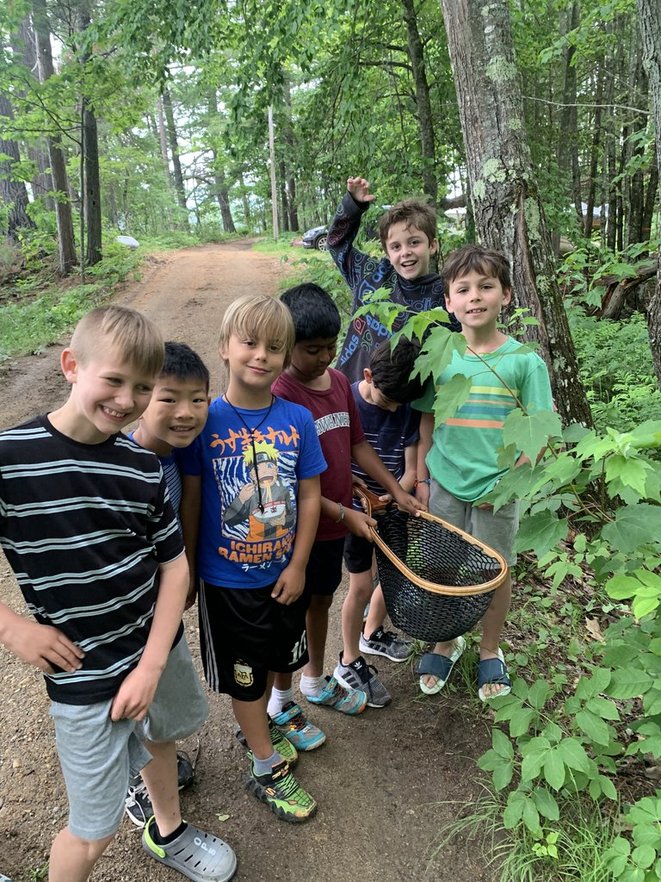 Campers with a landing net on a forest trail at Camp Kawanhee
