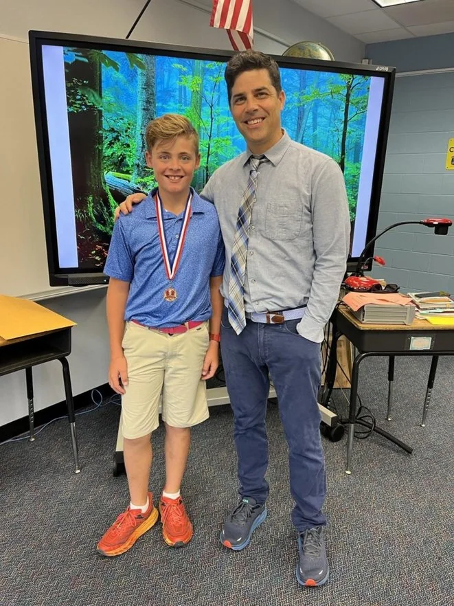 Kevin Bonasera with a student receiving a classroom award