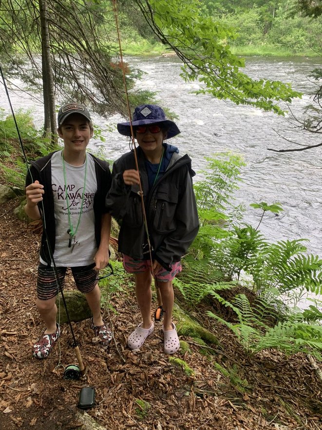 Camp Kawanhee campers with fly rods beside a river